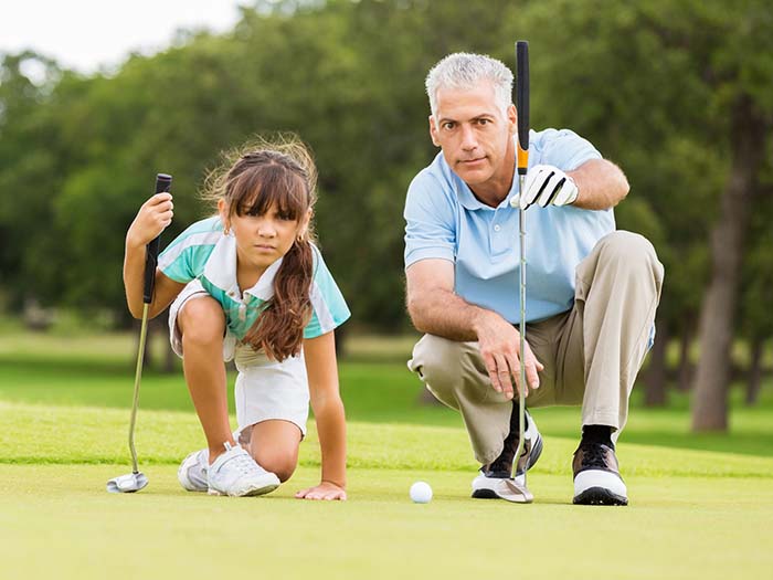 A person and a girl playing golf