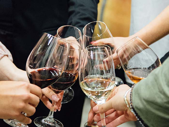 A group of people hold wine glasses