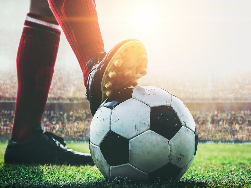 person with their foot on soccer ball