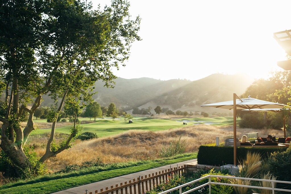 A golf course with a tree and a building