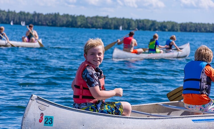 A boy in a canoe on a lake