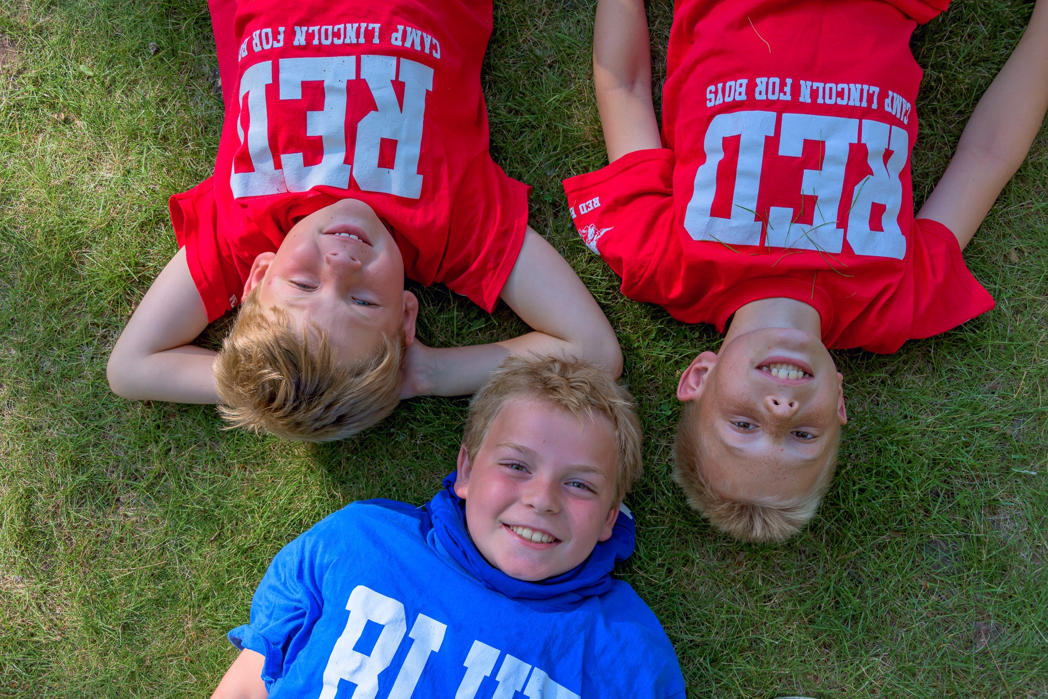 A group of boys lying on grass
