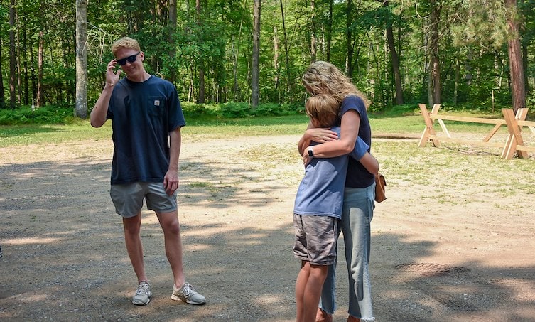 A man and woman hugging a child
