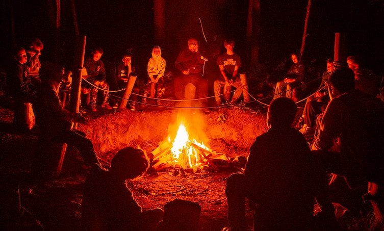A group of people sitting around a fire