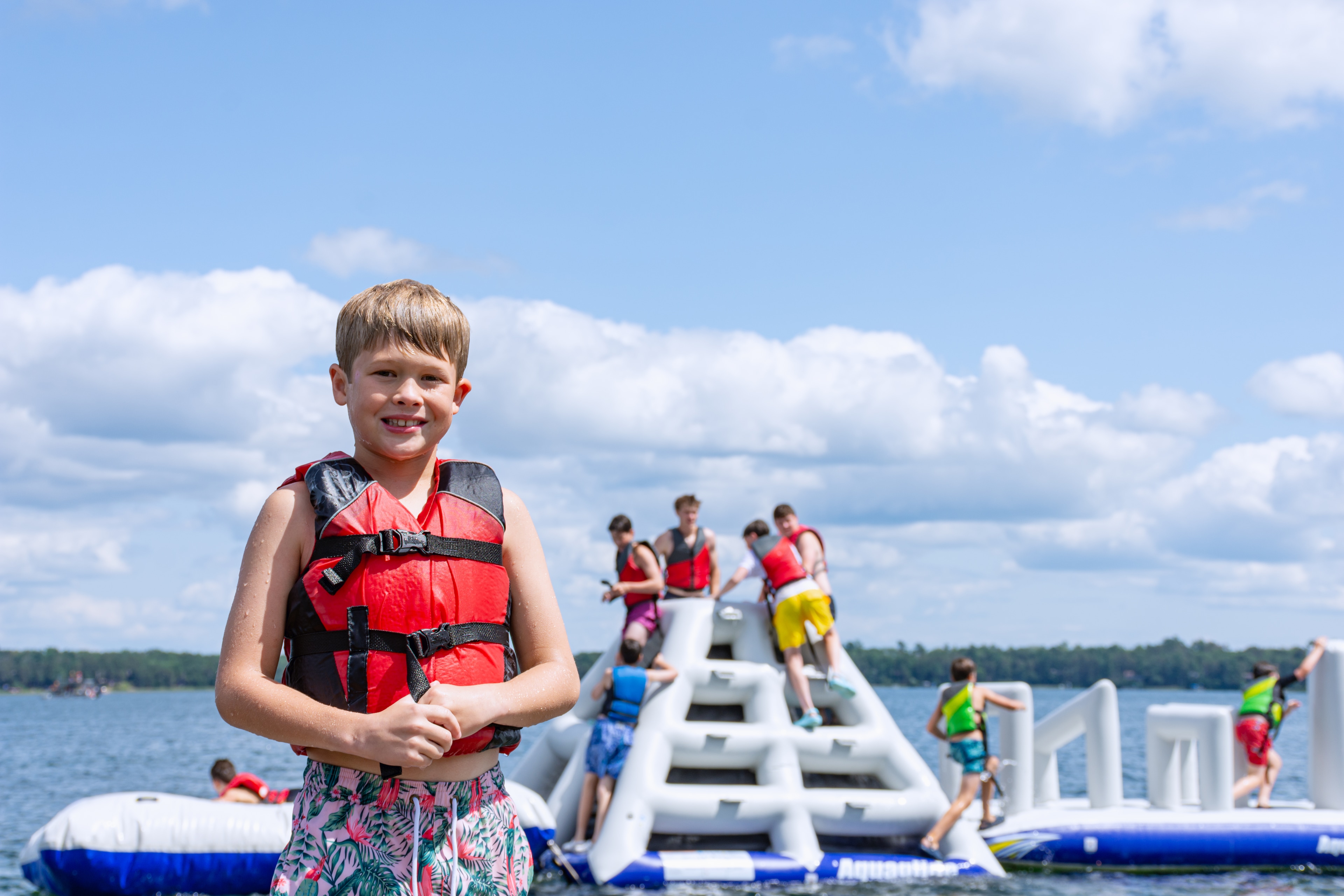 A boy in a life jacket on a floating raft