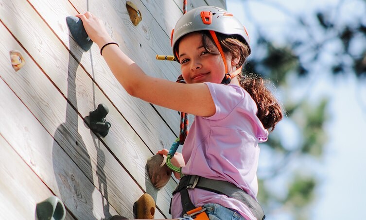 A girl climbing a rock wall