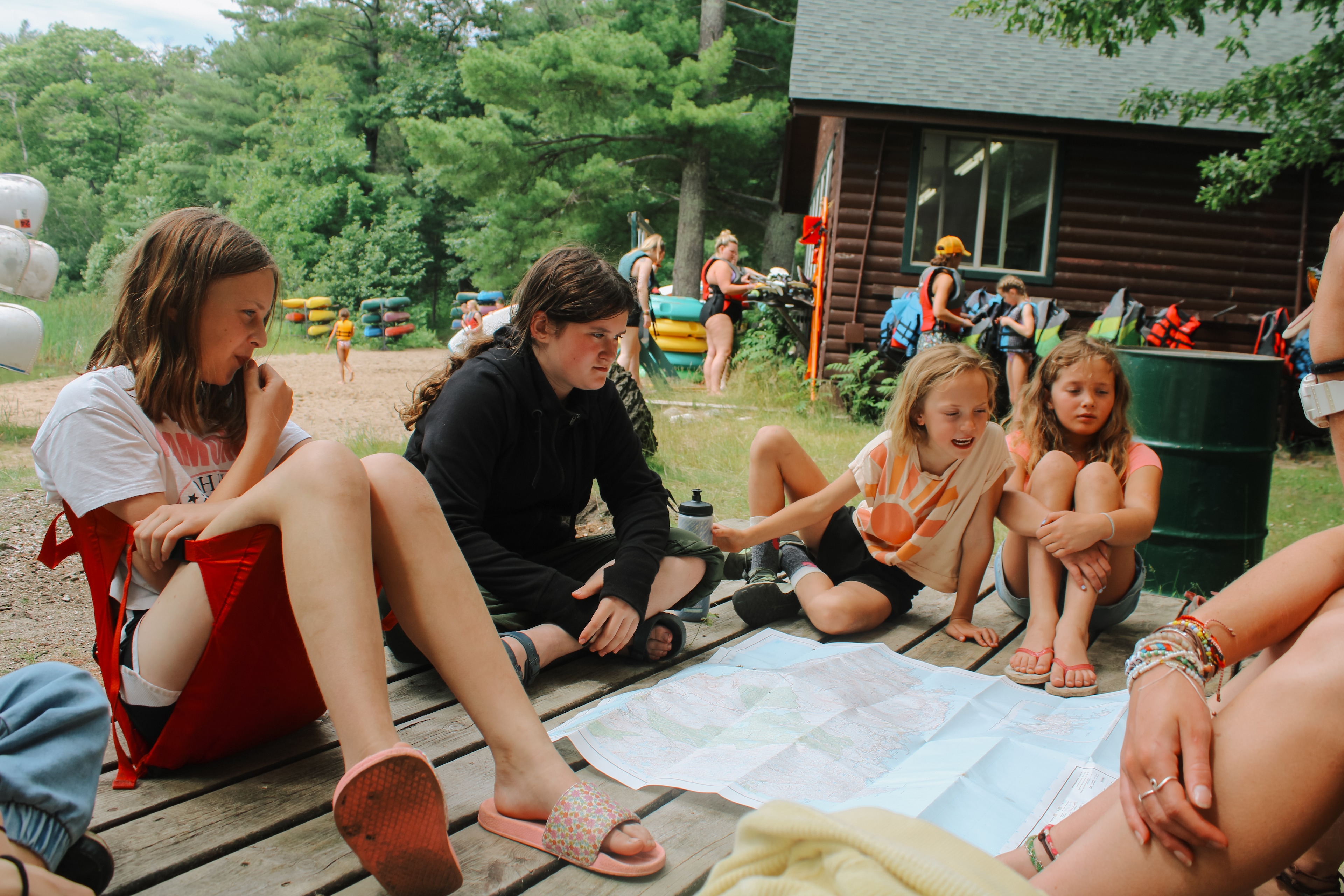 A group of people sitting on a deck with a map