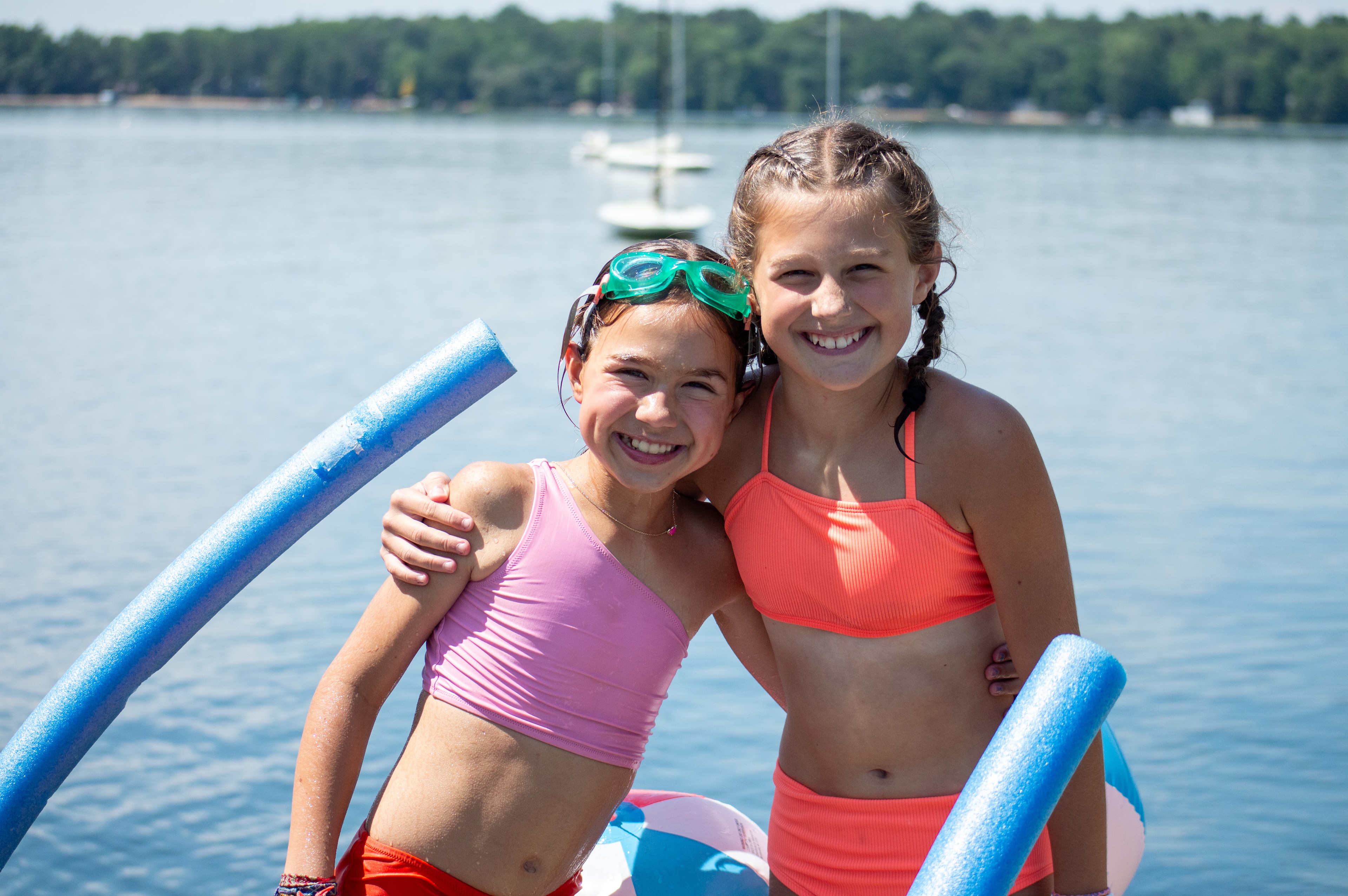 Two girls in swimsuits on a raft in the water