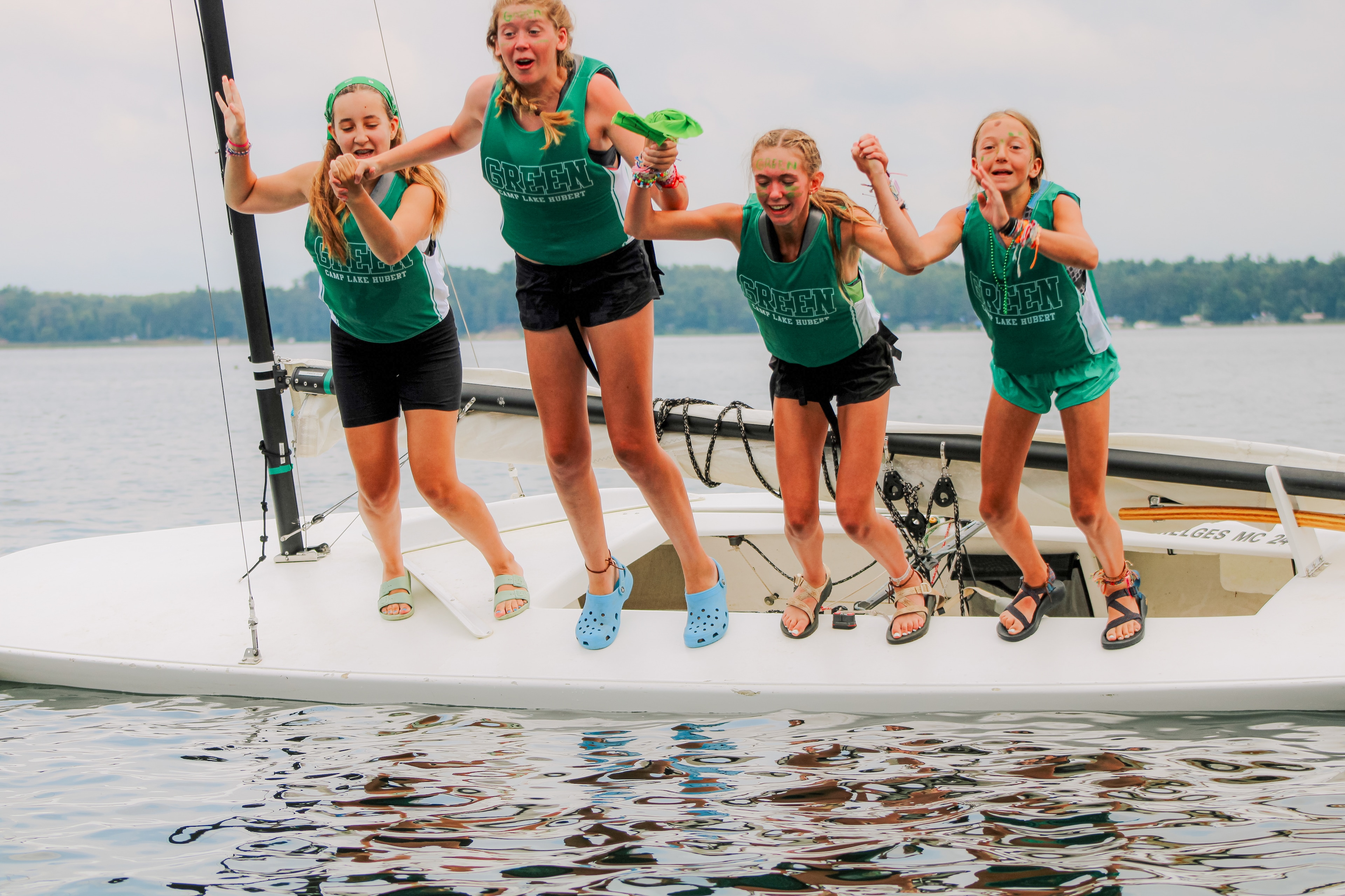 A group of girls jumping on a boat