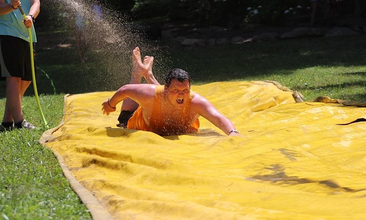 A man sliding down a yellow water slide