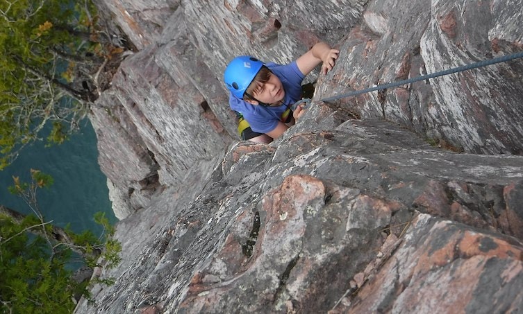 A boy climbing a rock wall