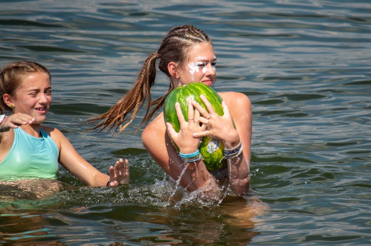 Camp Lake Hubert camper playing fun games in the water playing pass the watermelon
