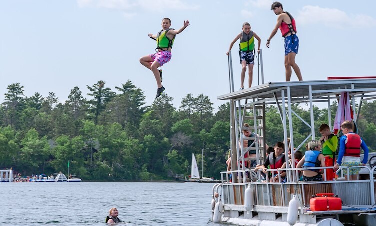 A group of people jumping off a dock