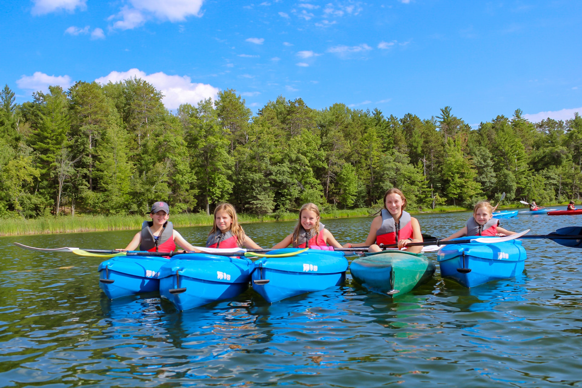 A group of people in kayaks on a lake