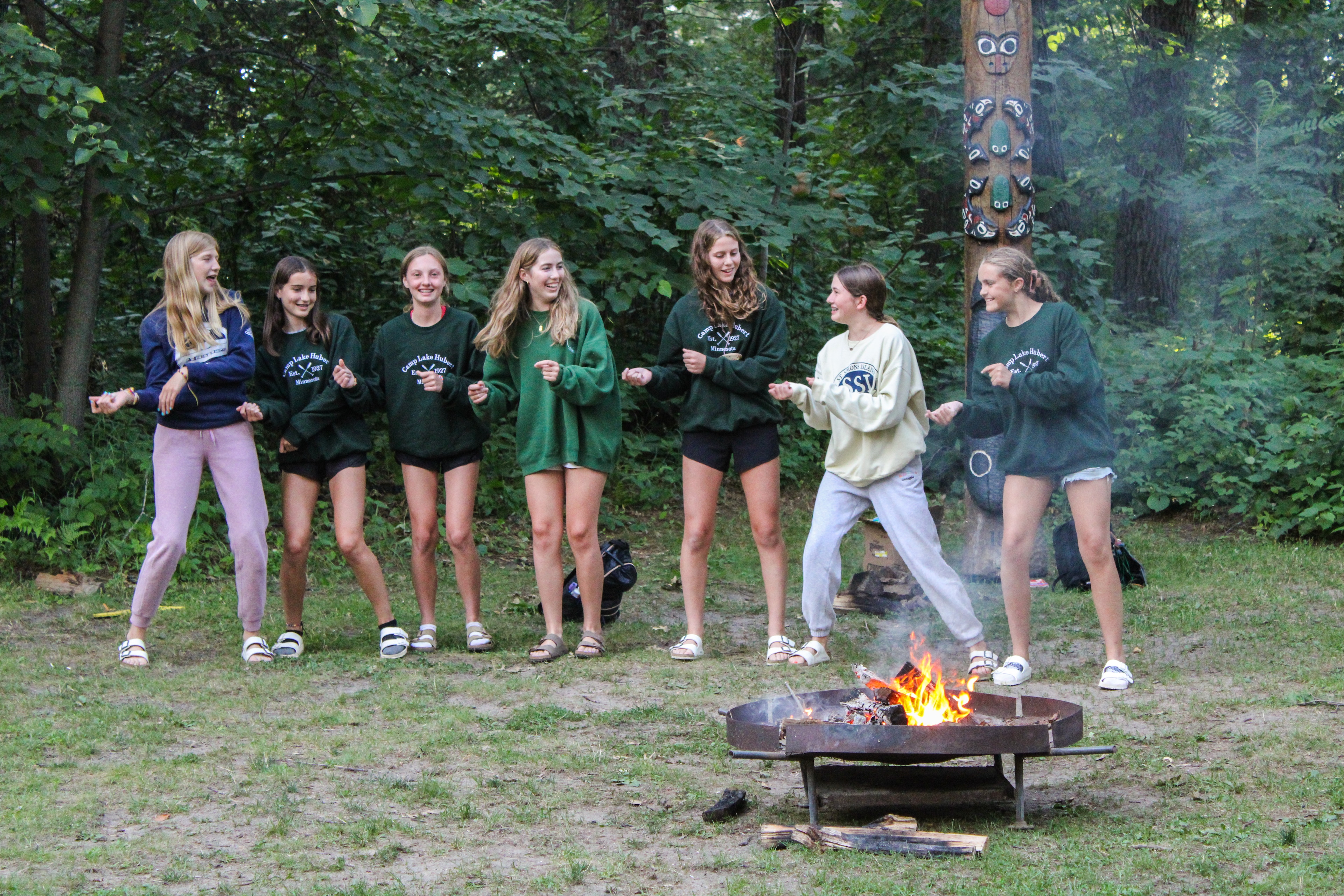 Camp Lake Hubert for girls having fun around the camp fire.