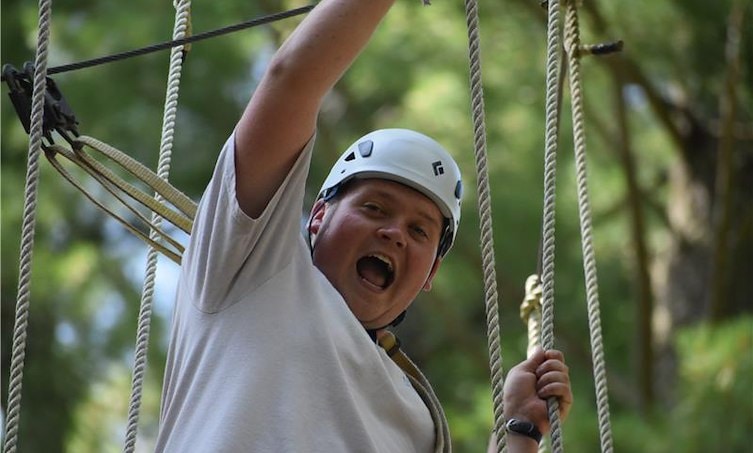 A man wearing a helmet and holding ropes