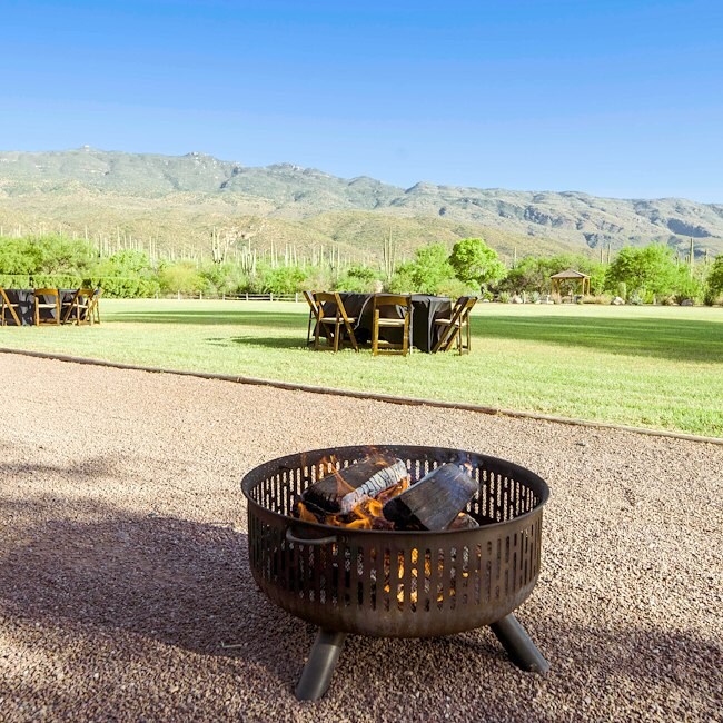 A fire pit in a gravel area with outdoor seating and a mountain view.