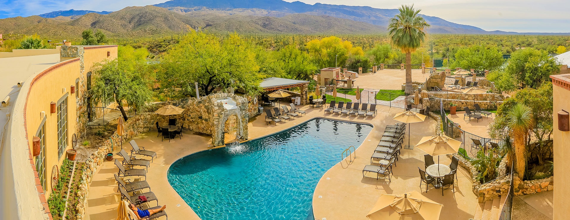 A large pool with a waterfall and mountain view