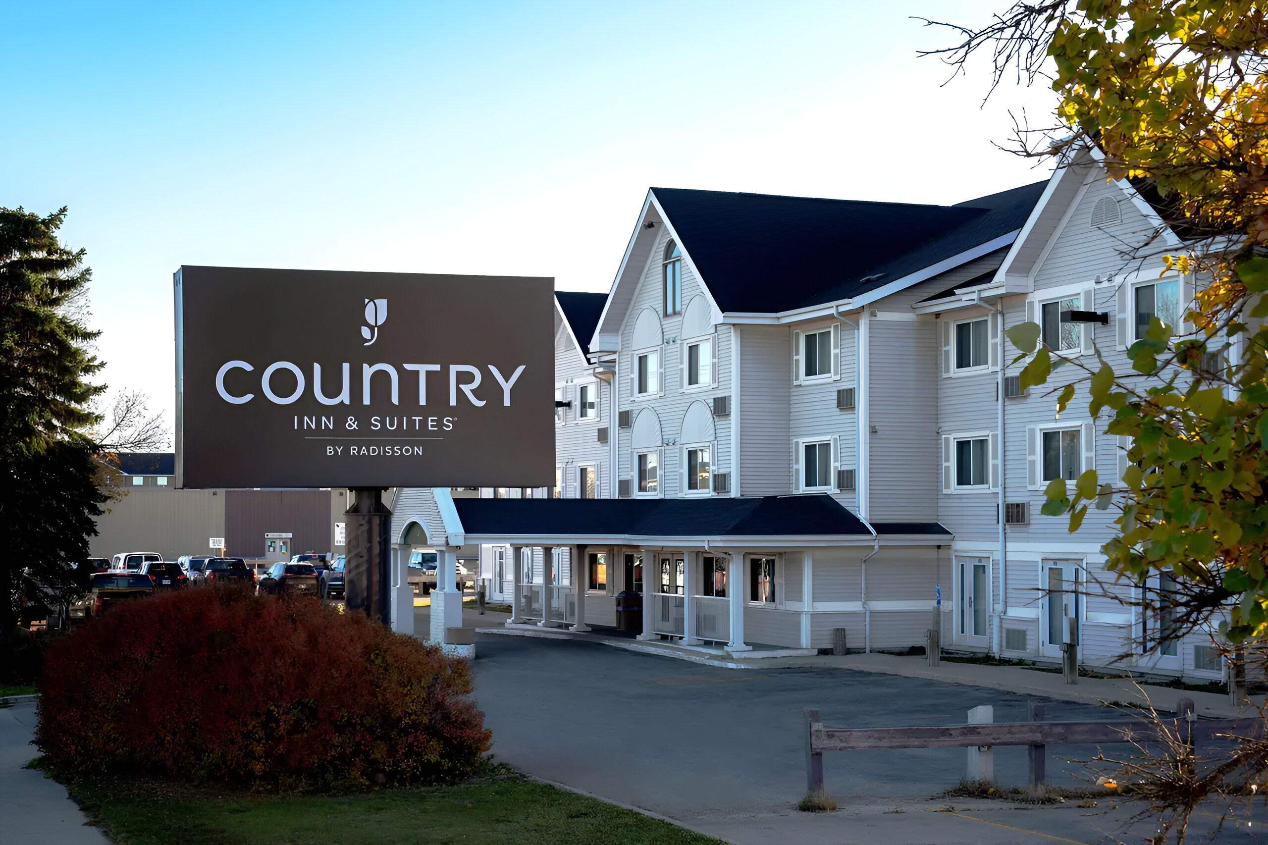 Exterior view of a white Country Inn & Suites by Radisson hotel, with black roof and multiple windows