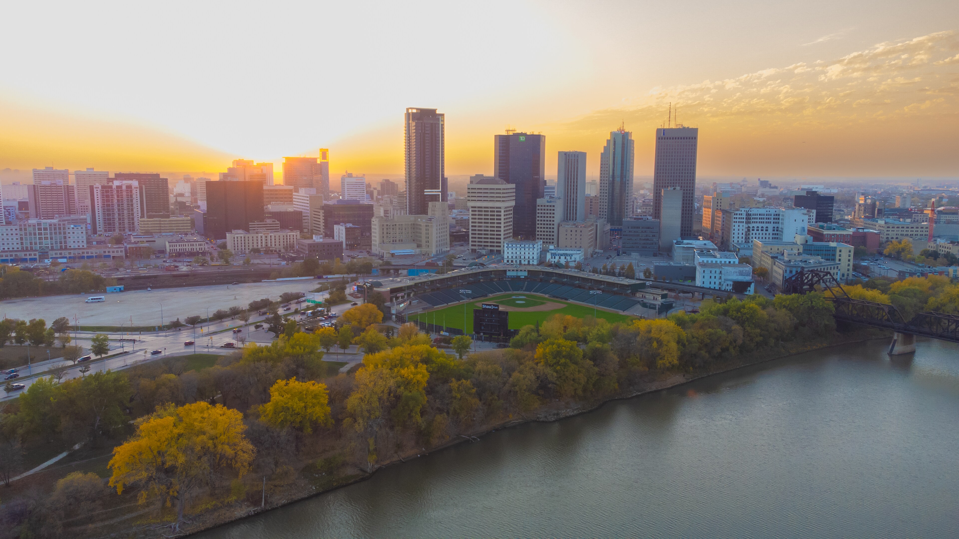 Aerial view of a cityscape at sunset with tall buildings