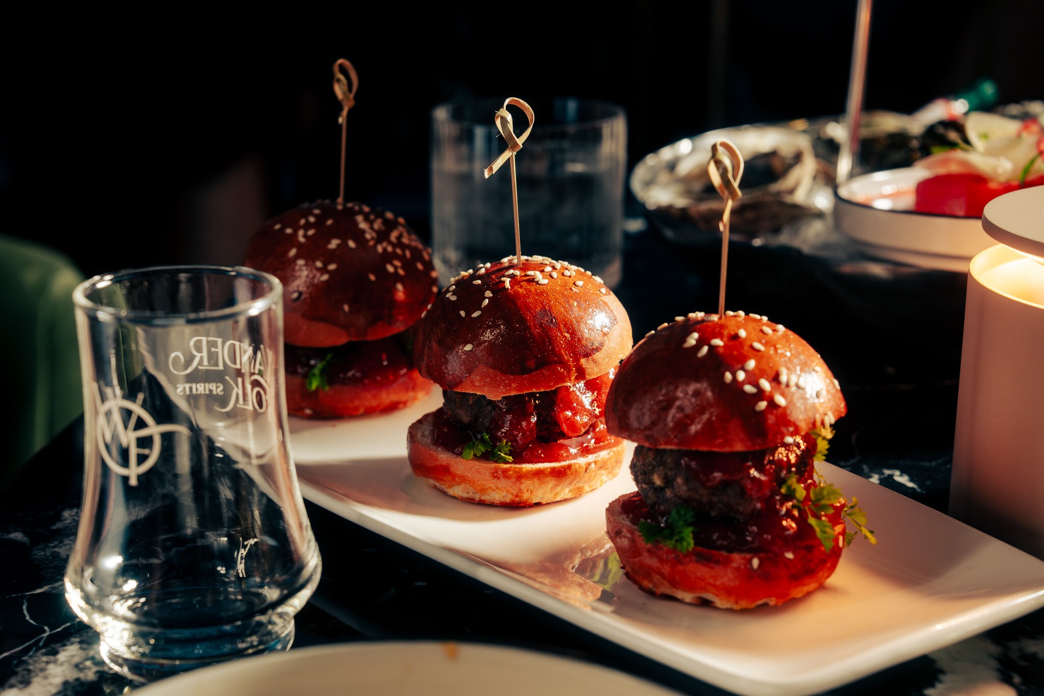 A table topped with small hamburgers and glasses of wine, Nova Lounge at Vast, Oklahoma