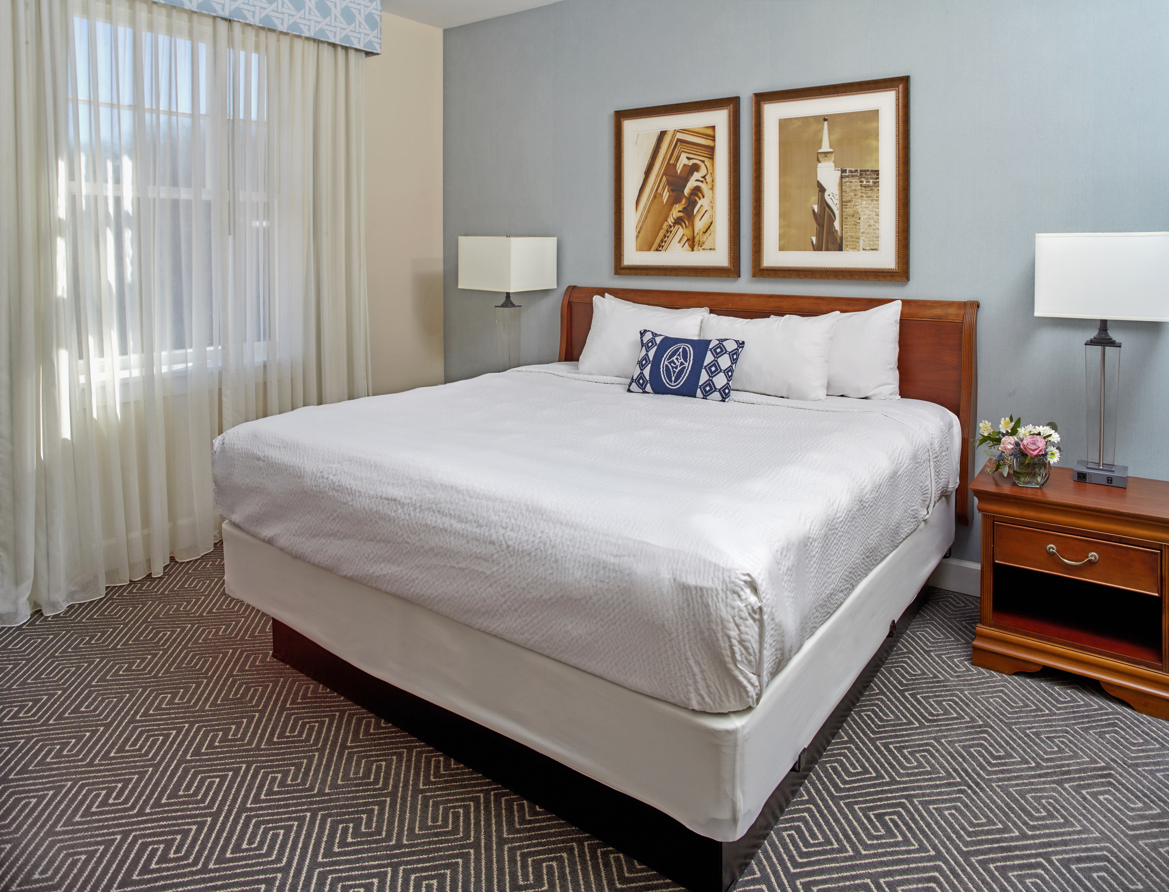 Bright guest room with a plush bed and blue accents at Hotel 24 South in Staunton, Virginia
