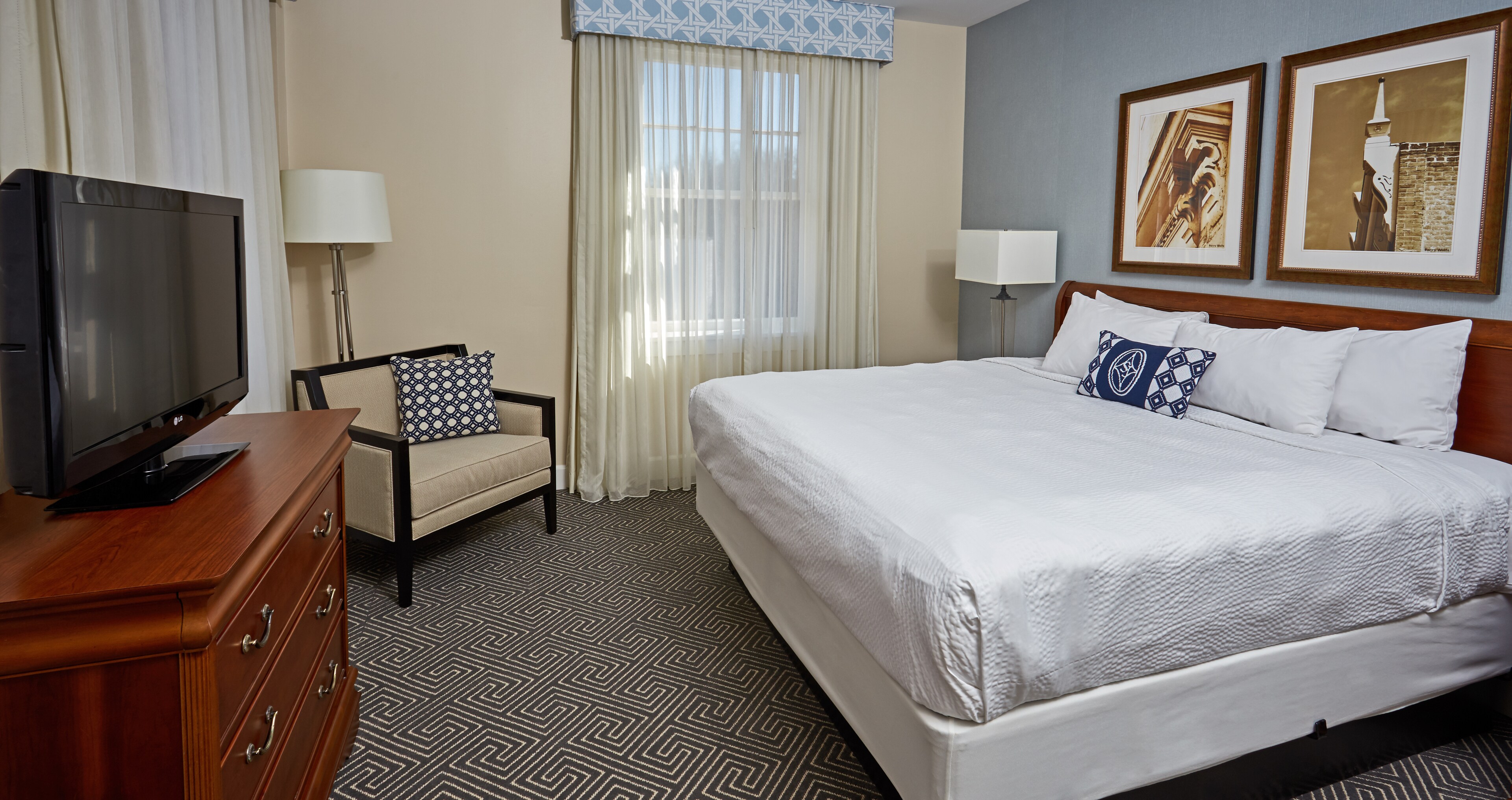 Modern king guest room with a plush white bed and framed local art at Hotel 24 South in Staunton, Virginia