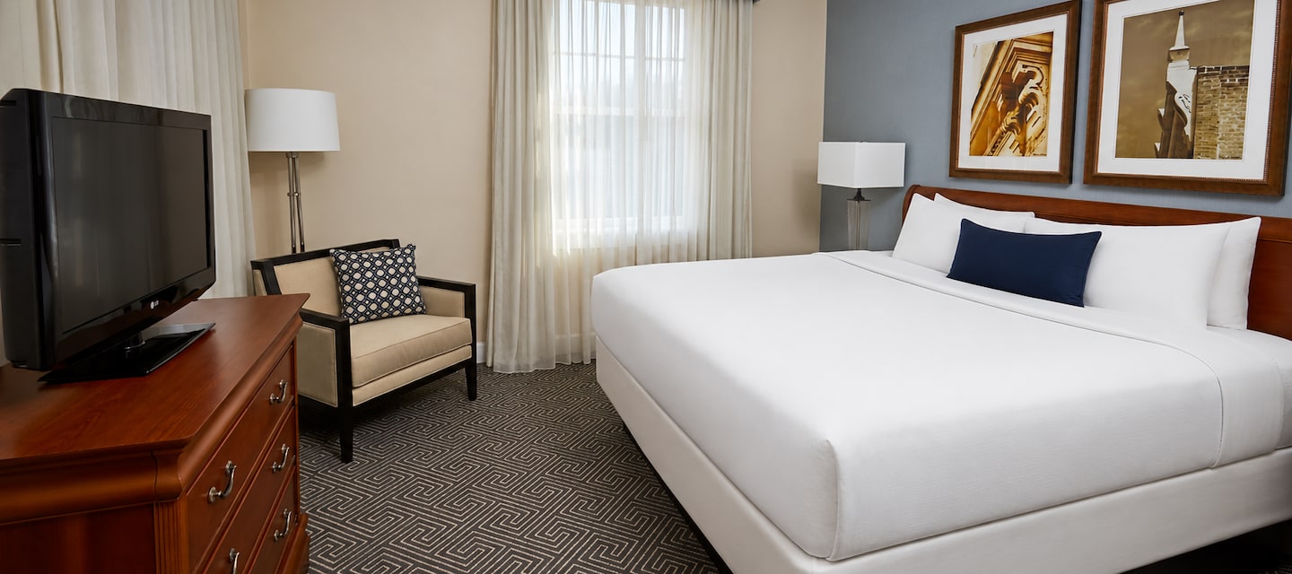 Modern king guest room with a plush white bed and framed local art at Hotel 24 South in Staunton, Virginia