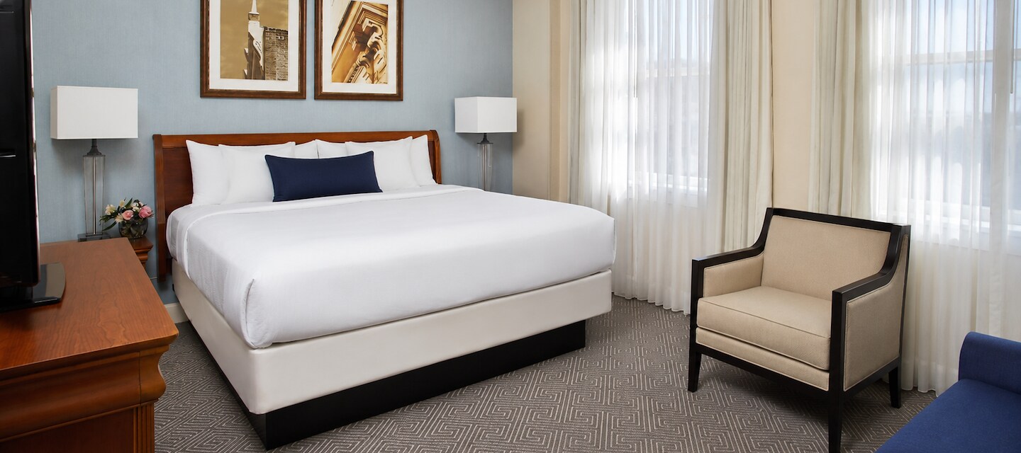 Bright guest room with a plush bed and blue accents at Hotel 24 South in Staunton, Virginia