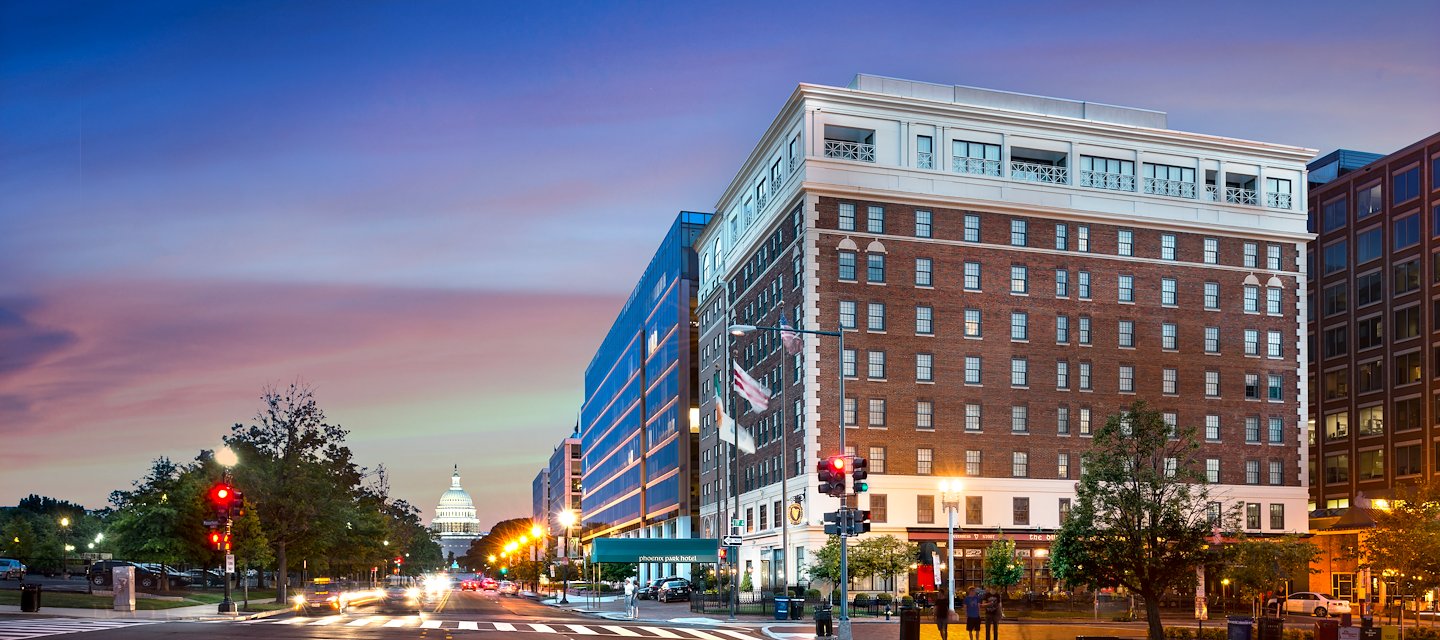Outdoor shot of Phoenix Park Hotel at night from across the street, includes the Capitol within the shot