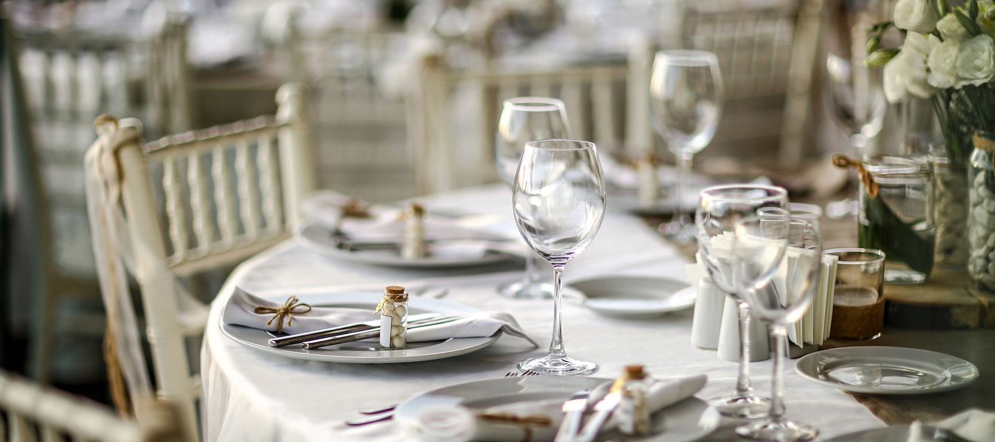 Elegant wedding reception table setup with glassware and white floral arrangements