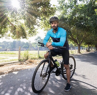 A cyclist in Kavi Nagar enjoys the outdoors near Brij Medical Centre.