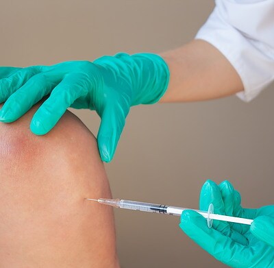 A healthcare professional administers a vaccine at Brij Medical Centre.