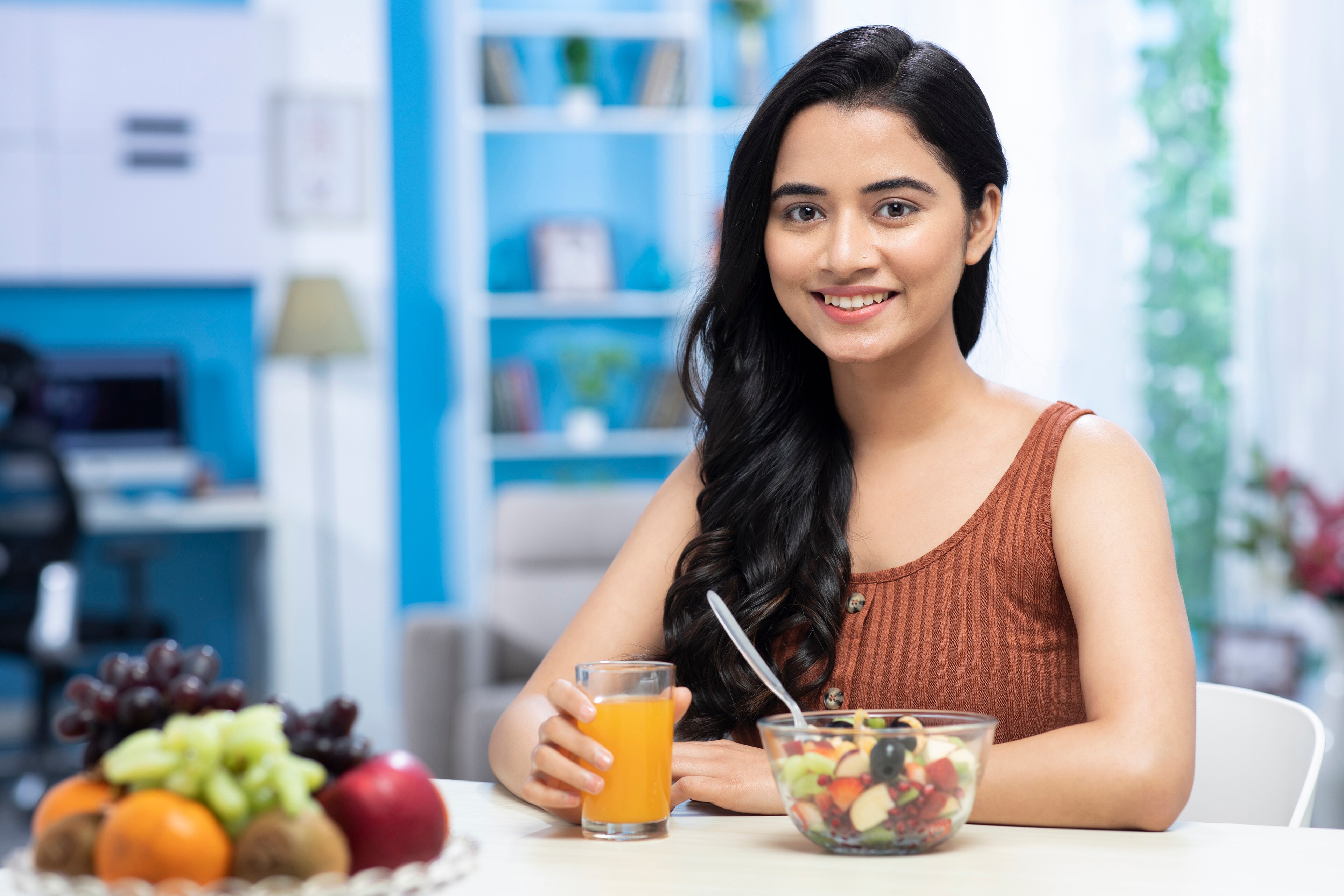 A smiling woman enjoys a healthy meal at Brij Medical Centre in Kavi Nagar.