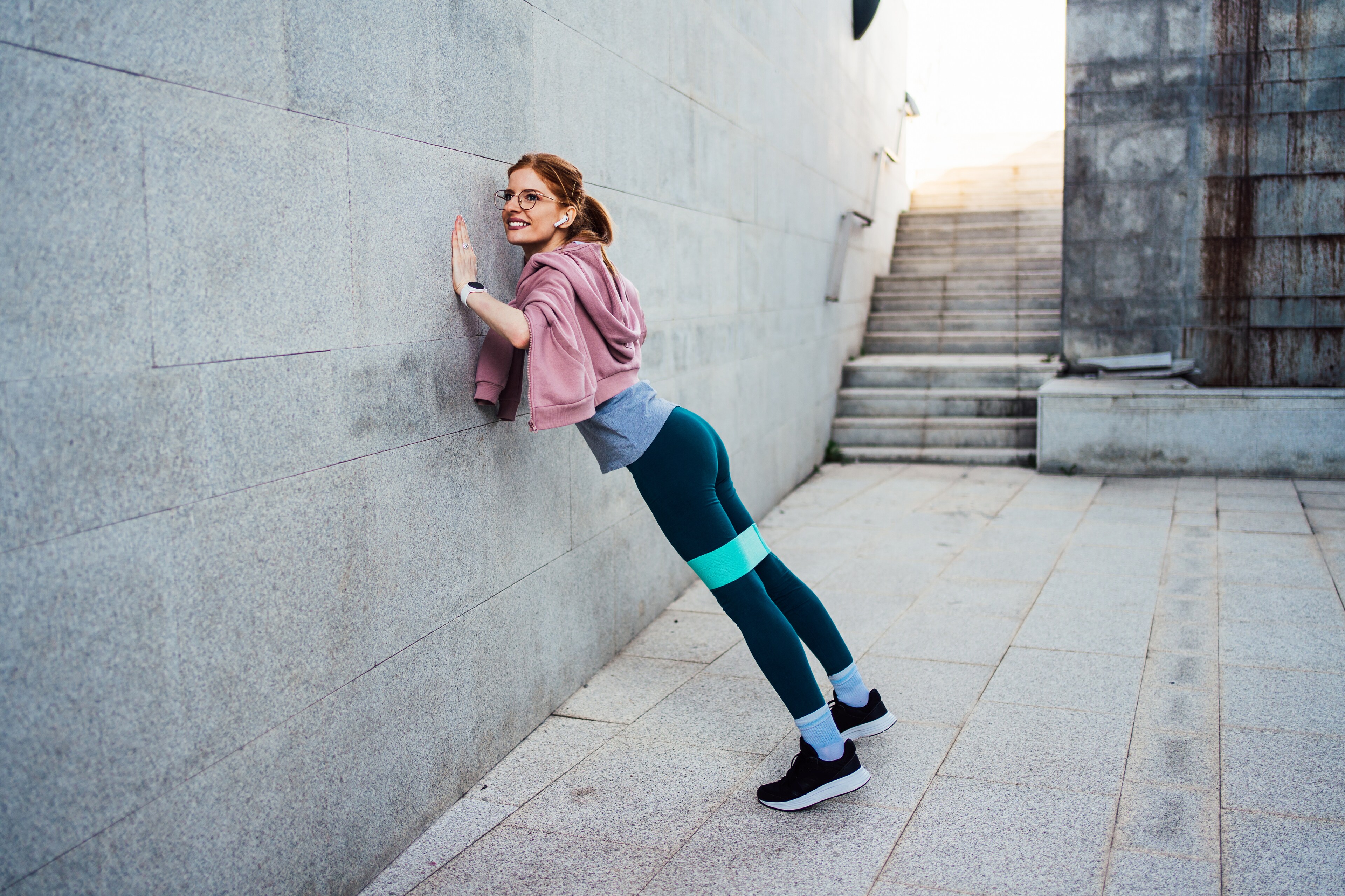 A woman exercises against a wall near Brij Medical Centre in Kavi Nagar.