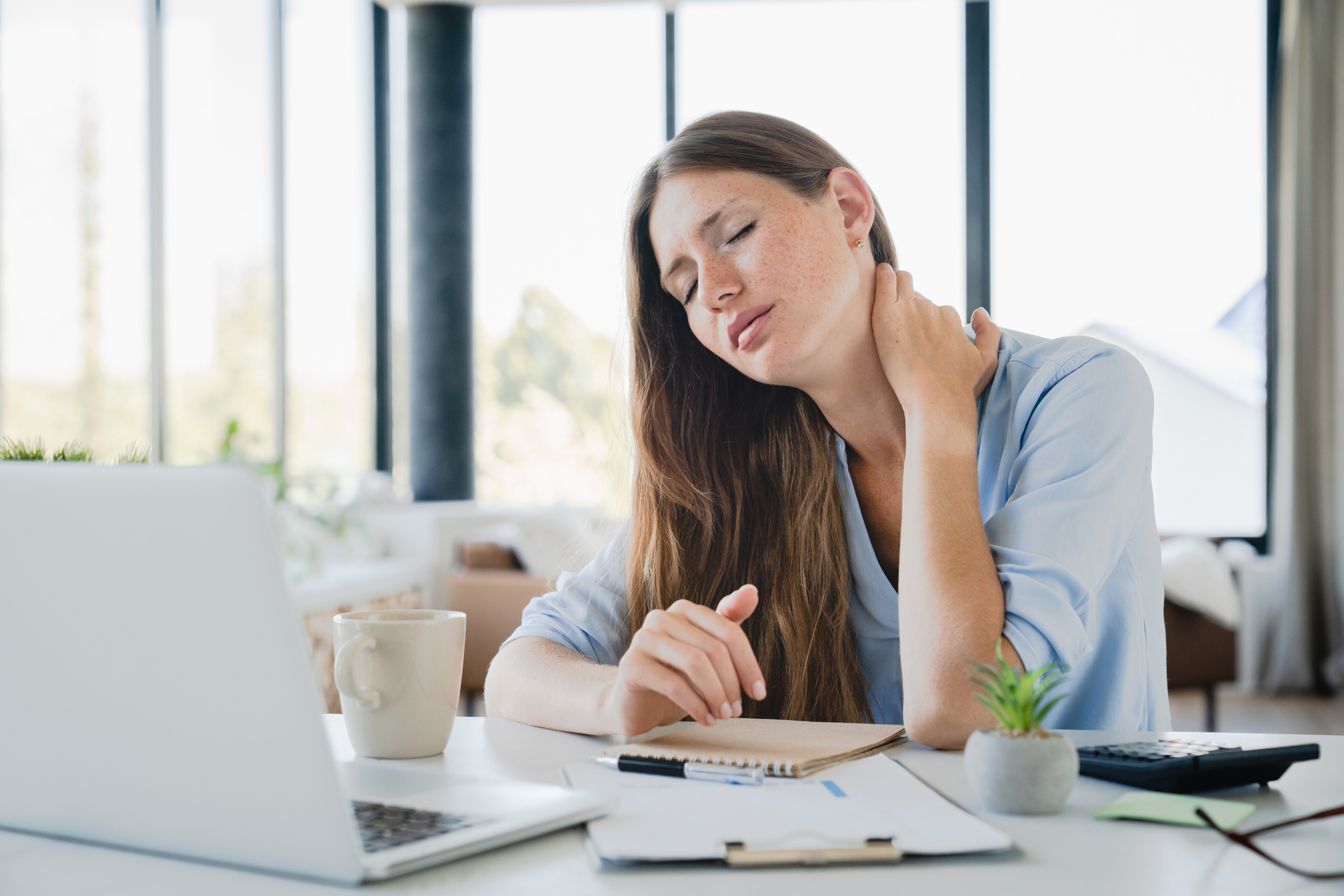 A woman experiencing neck pain seeks relief at Brij Medical Centre.