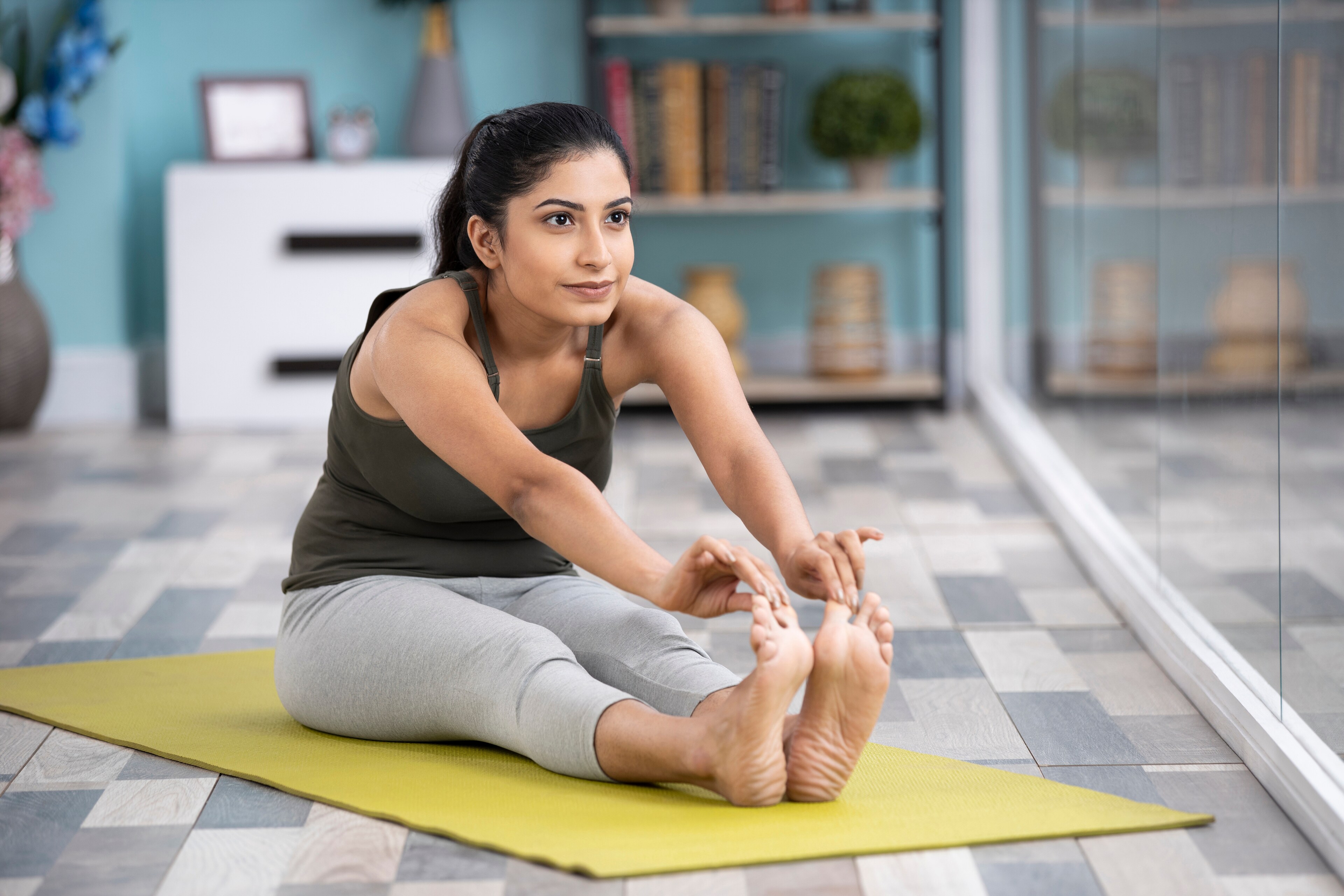 A woman stretches on a yoga mat at Brij Medical Centre in Kavi Nagar.
