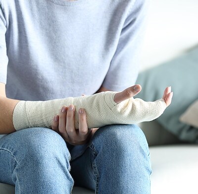 Disabled woman grabbing her painful bandaged arm.