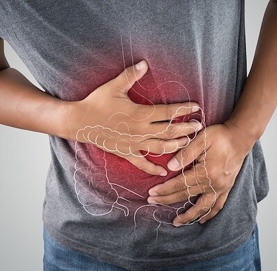 The photo of large intestine is on the man body against gray background.