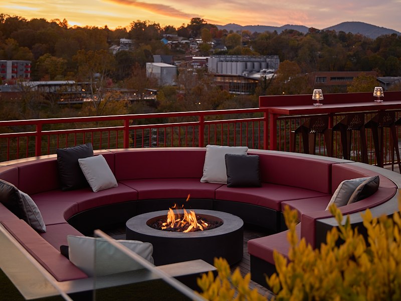 A fire pit on a deck with a view of a city and mountains