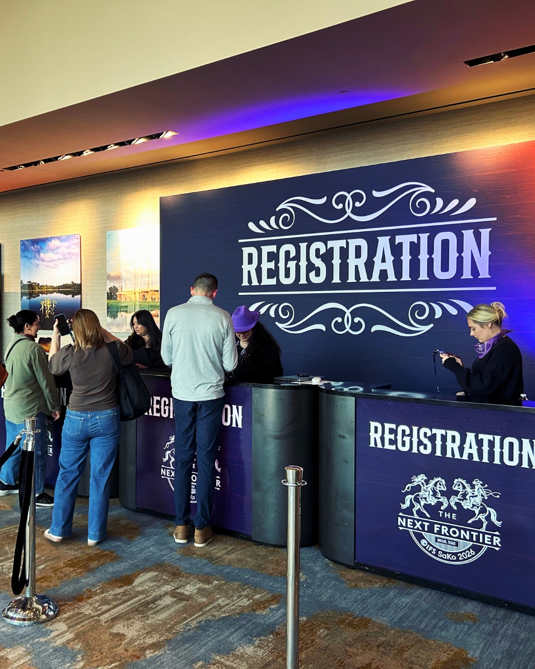 A group of people standing in front of a registration desk