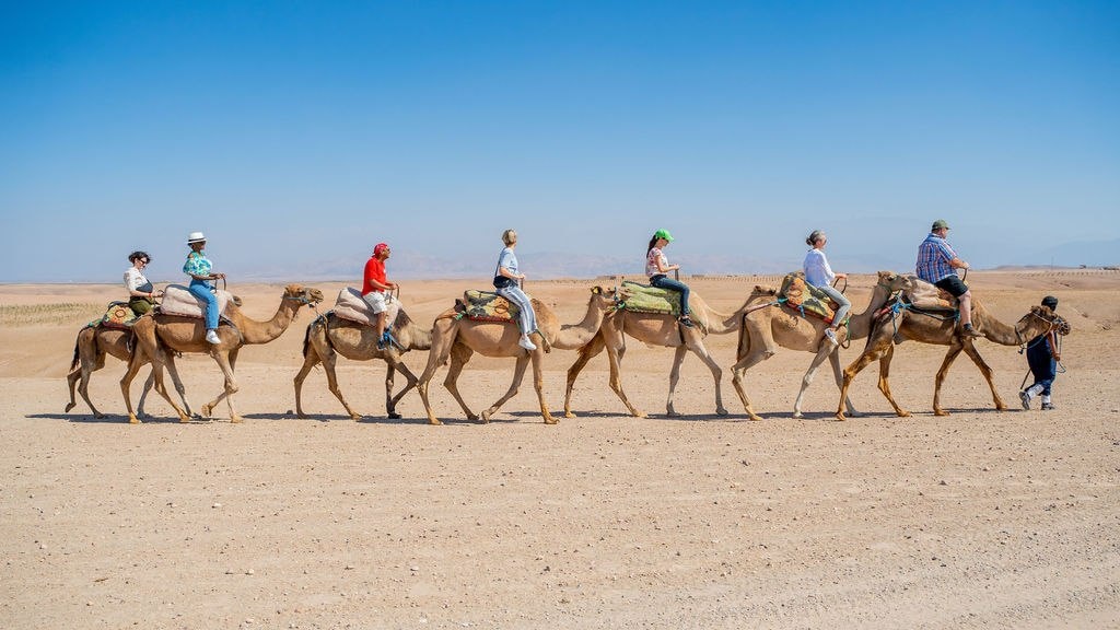A group of people riding camels in the desert