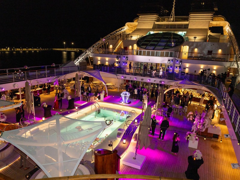 A large deck with people around it and a pool on it