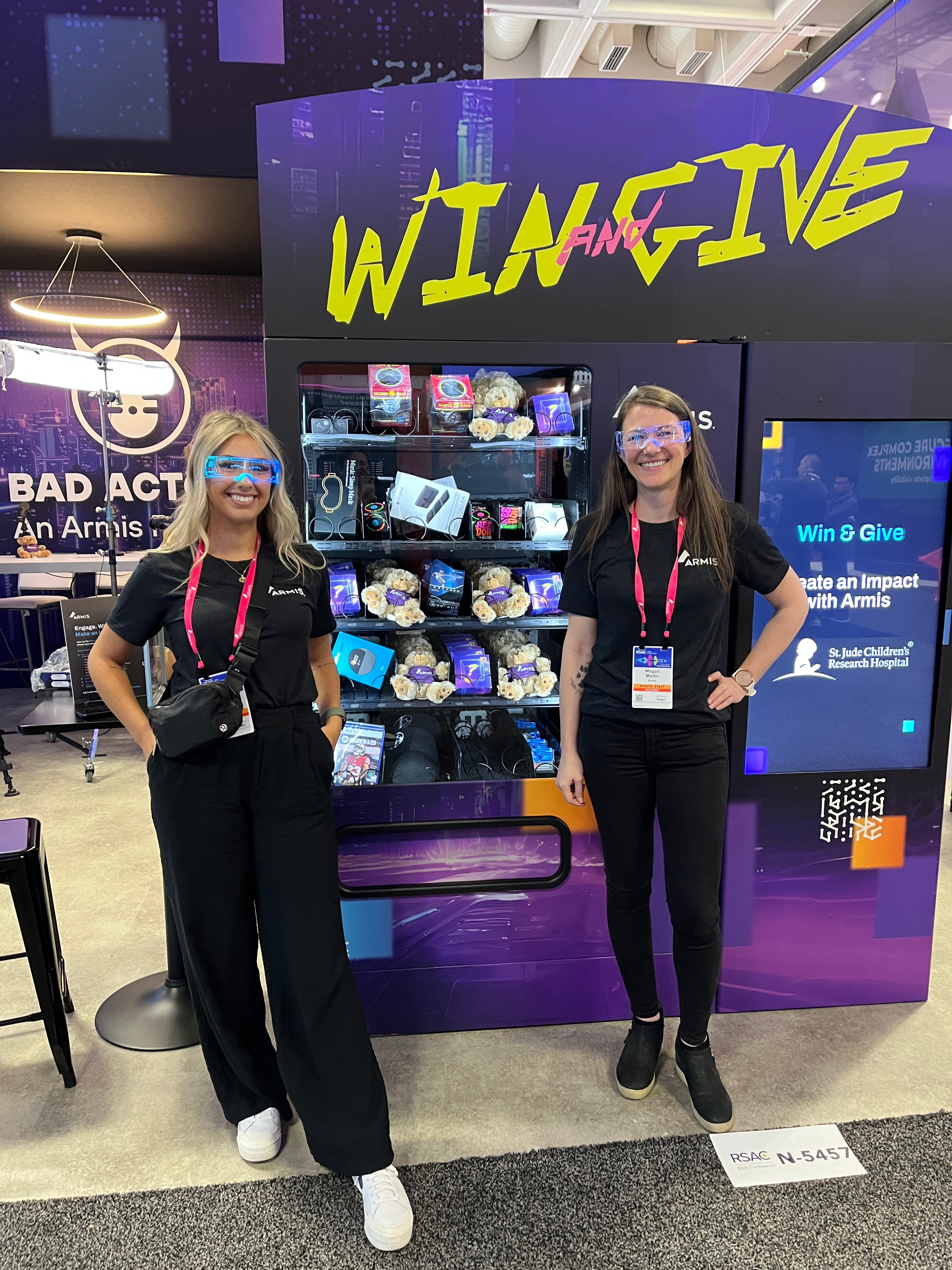 Two women standing in front of a vending machine
