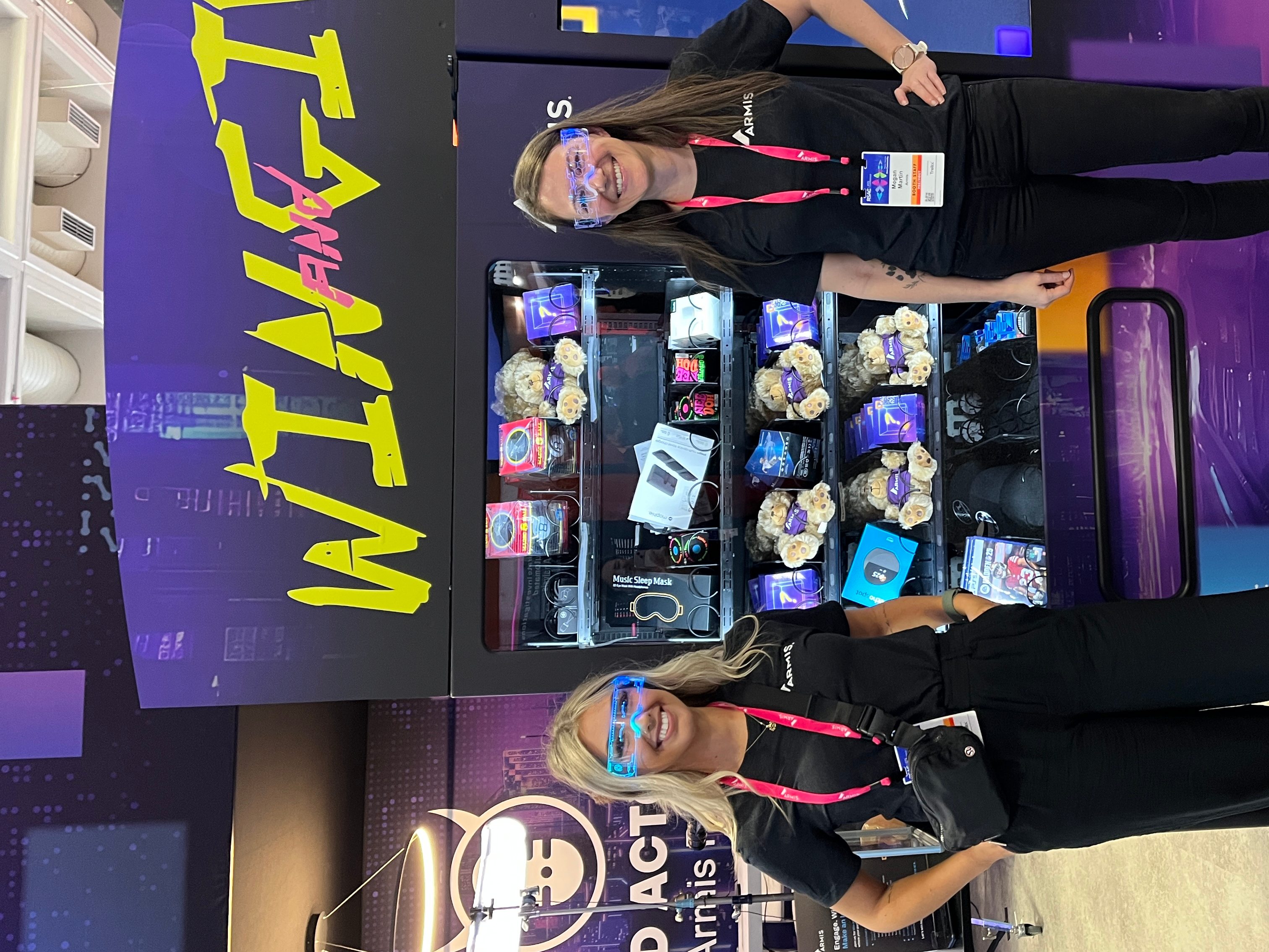 Two women standing in front of a vending machine