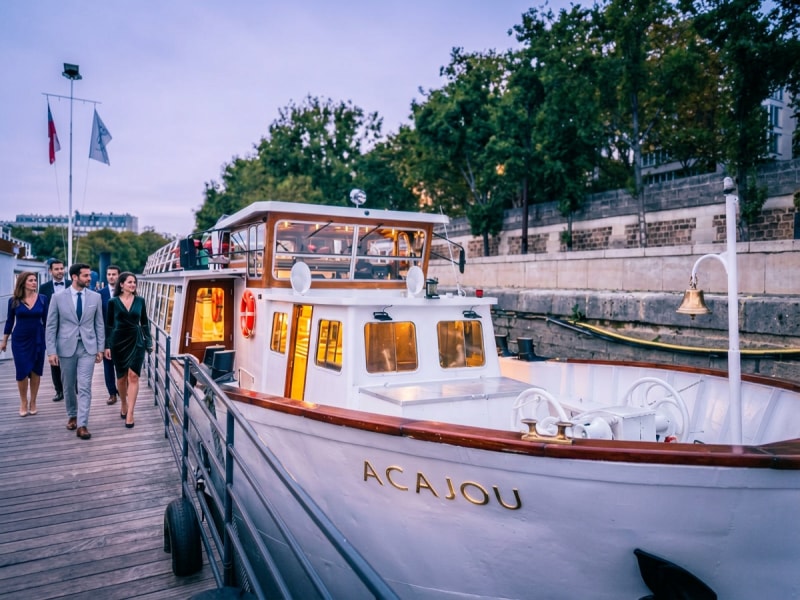 Dinner cruise boat docked on the Seine in Paris with passengers boarding