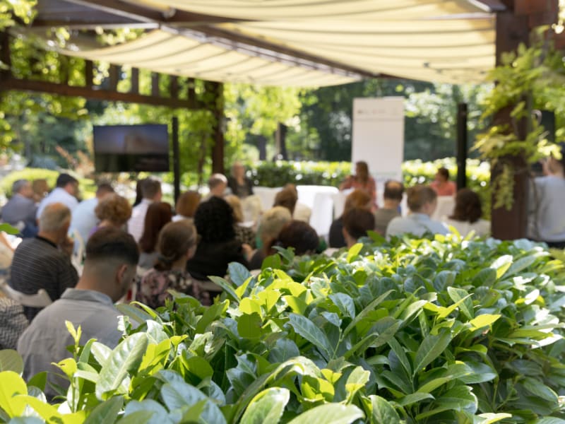 Outdoor corporate meeting under a canopy with live presentation
