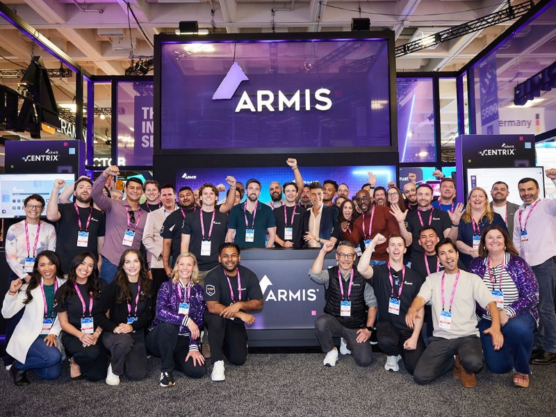 A group of people posing for a photo at a tradeshow booth