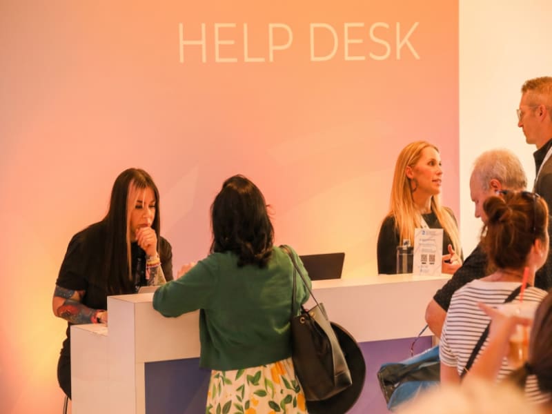 Attendees receiving assistance at an event help desk