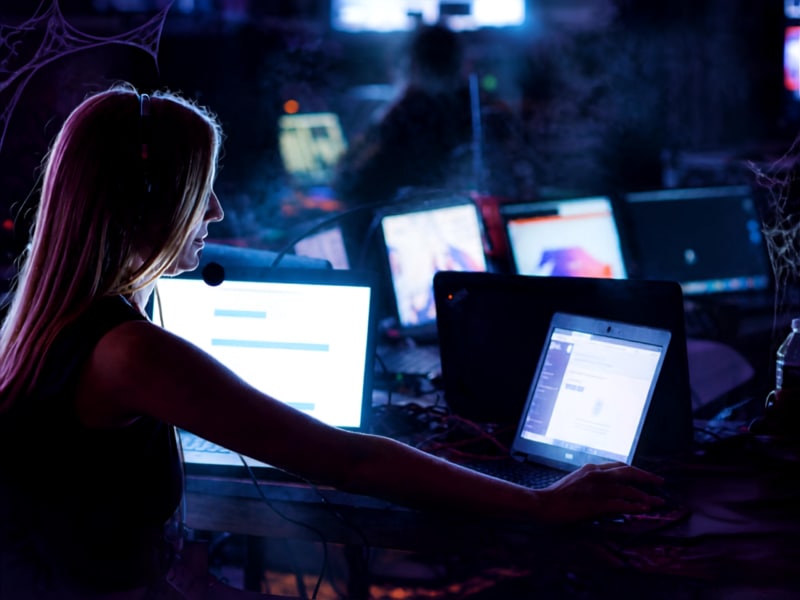 Person working at event production desk with multiple computer screens